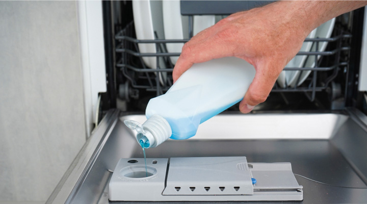 pouring detergent into dispenser of dishwasher