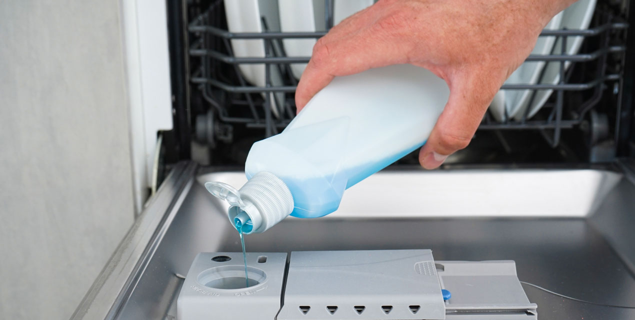 pouring detergent into dispenser of dishwasher